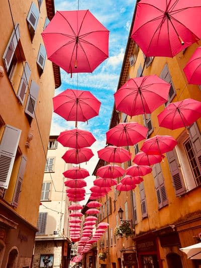 Pink parasols above an old-town lane in Grasse